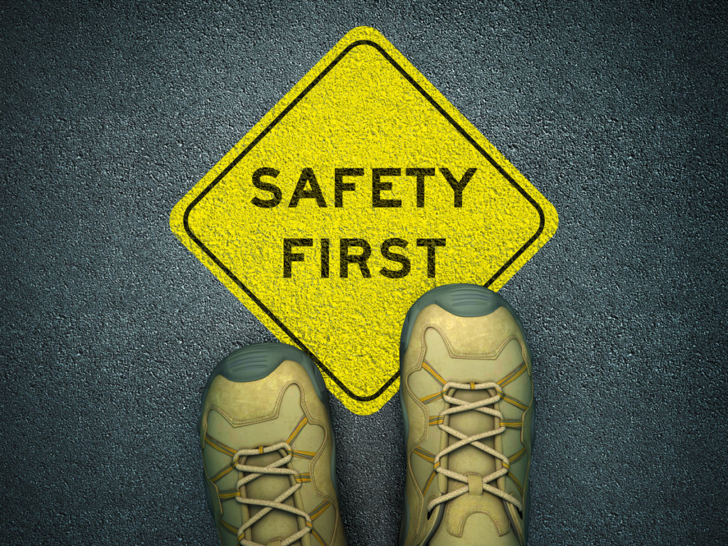Safety Footwear standing next to 'safety first' sign